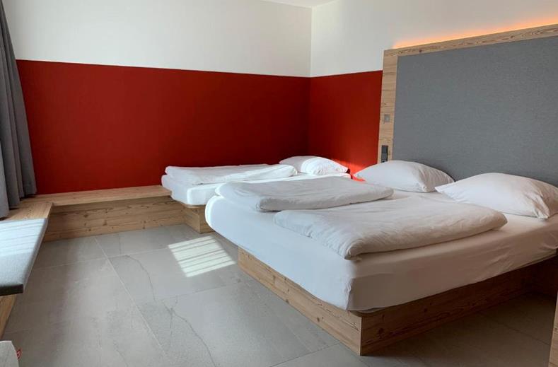 Een moderne familiekamer in het FAIR Resort met een tweepersoonsbed en een apart kinderbed, ideaal voor gezinnen.