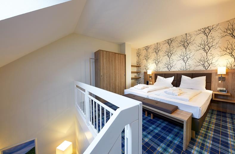 Het slaapgedeelte op de bovenverdieping van de maisonnette familiekamer in Göbels Seehotel Diemelsee.