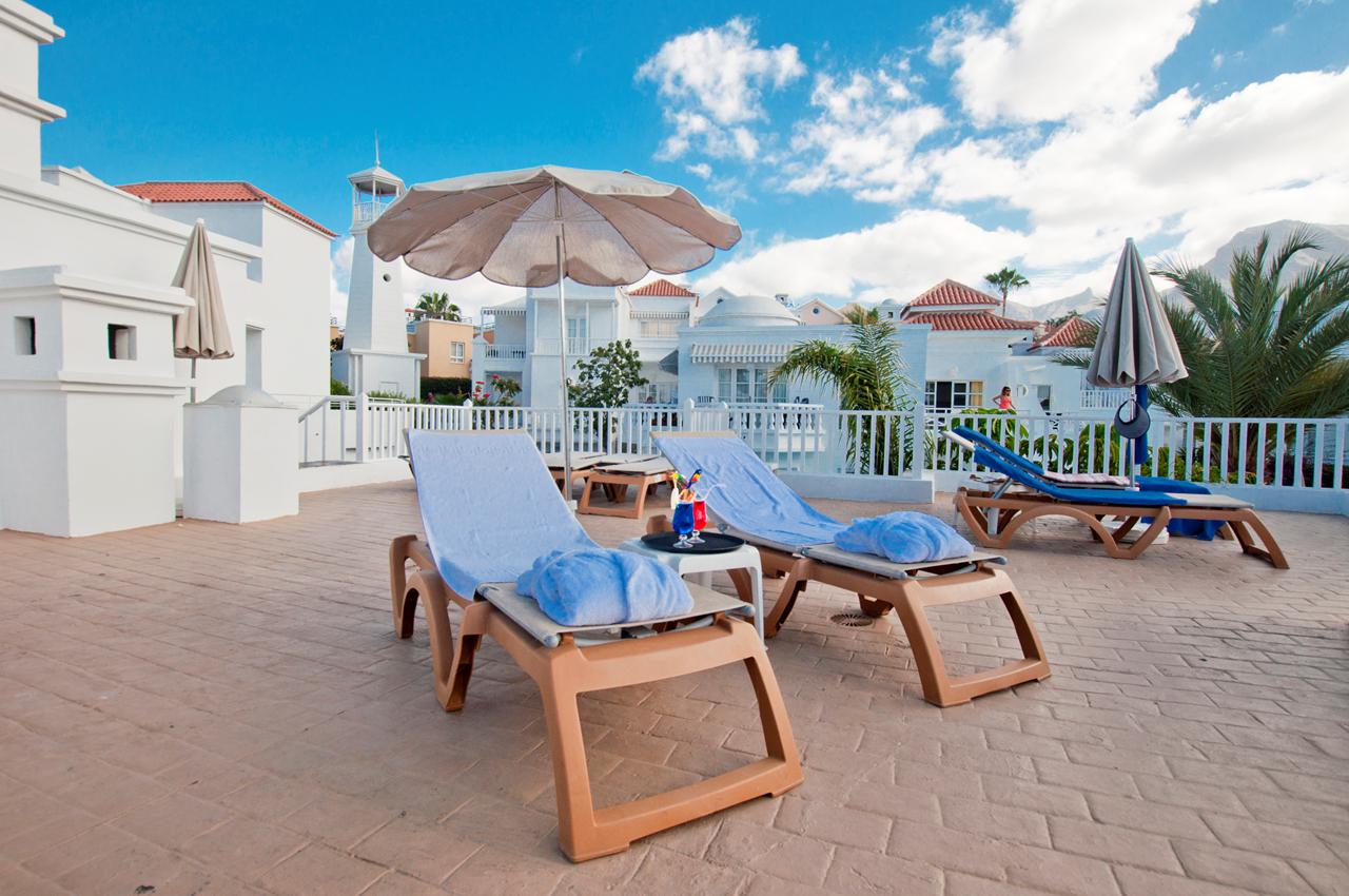 Overzicht van het grote zwembad in rivierstijl, omringd door ligbedden en parasols, perfect voor gezinnen.