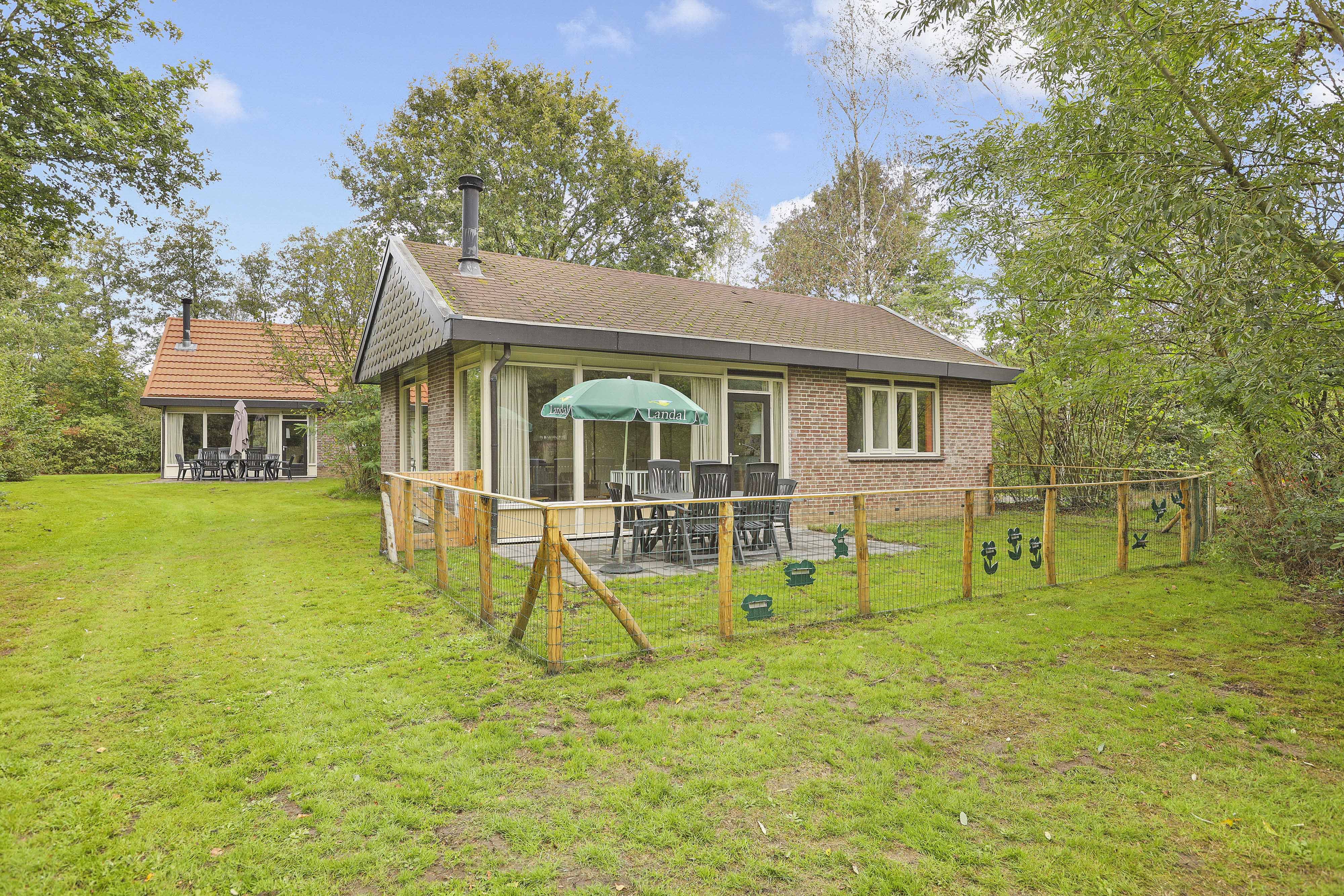 Een vrijstaande bungalow op Landal Aelderholt in Drenthe met een ruime, omheinde tuin, terras en een eigen klein speeltoestel voor de kinderen.