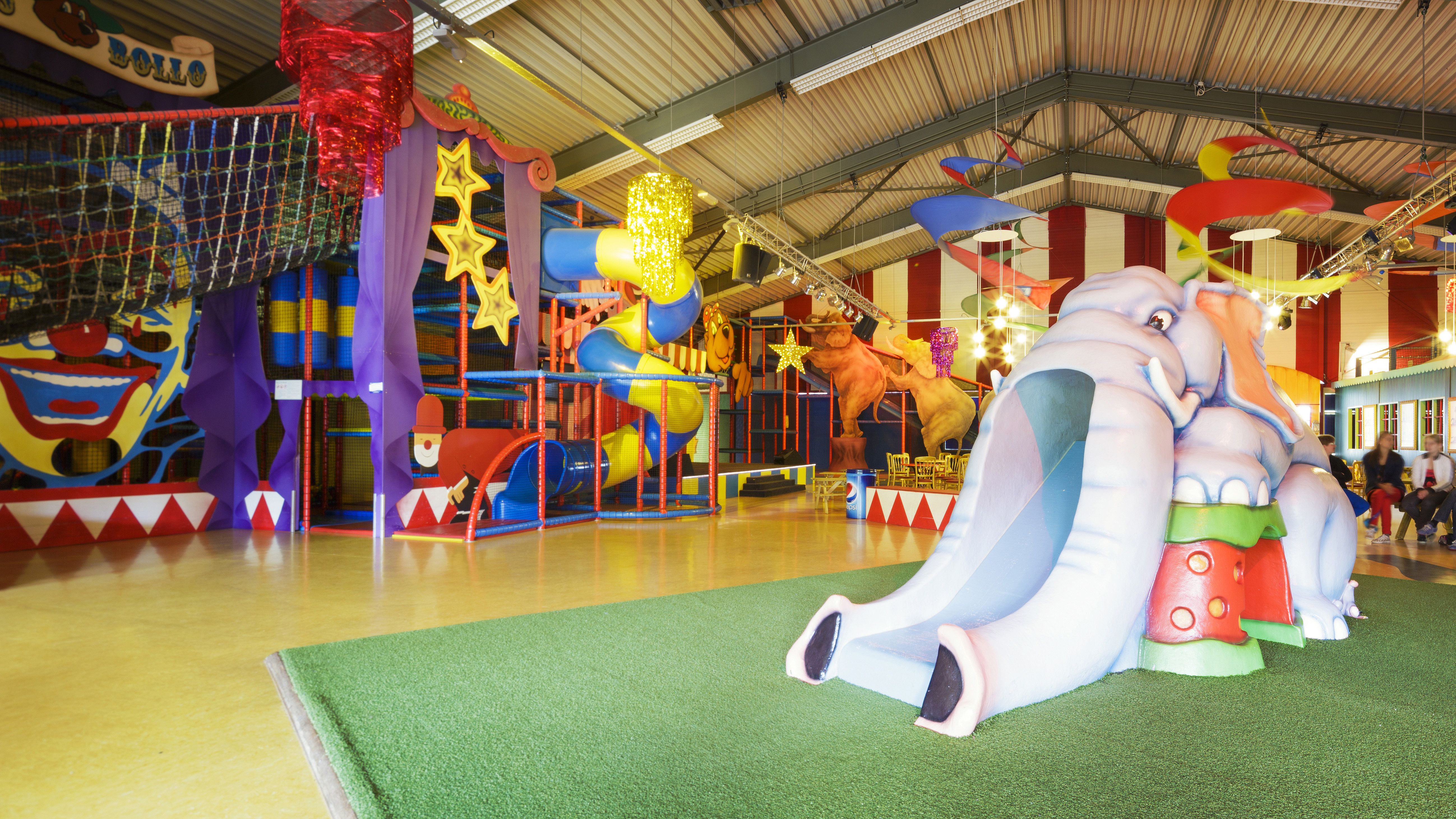 Een groot en kleurrijk indoorspeelparadijs bij Landal Aelderholt met een olifantenglijbaan, klimrekken en ballenbakken waar kinderen zich kunnen vermaken.