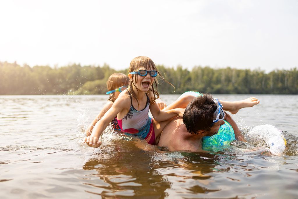 Twee kinderen zwemmen en spelen op een zonnige dag in het recreatiemeer bij Landal De Wedderplassen.