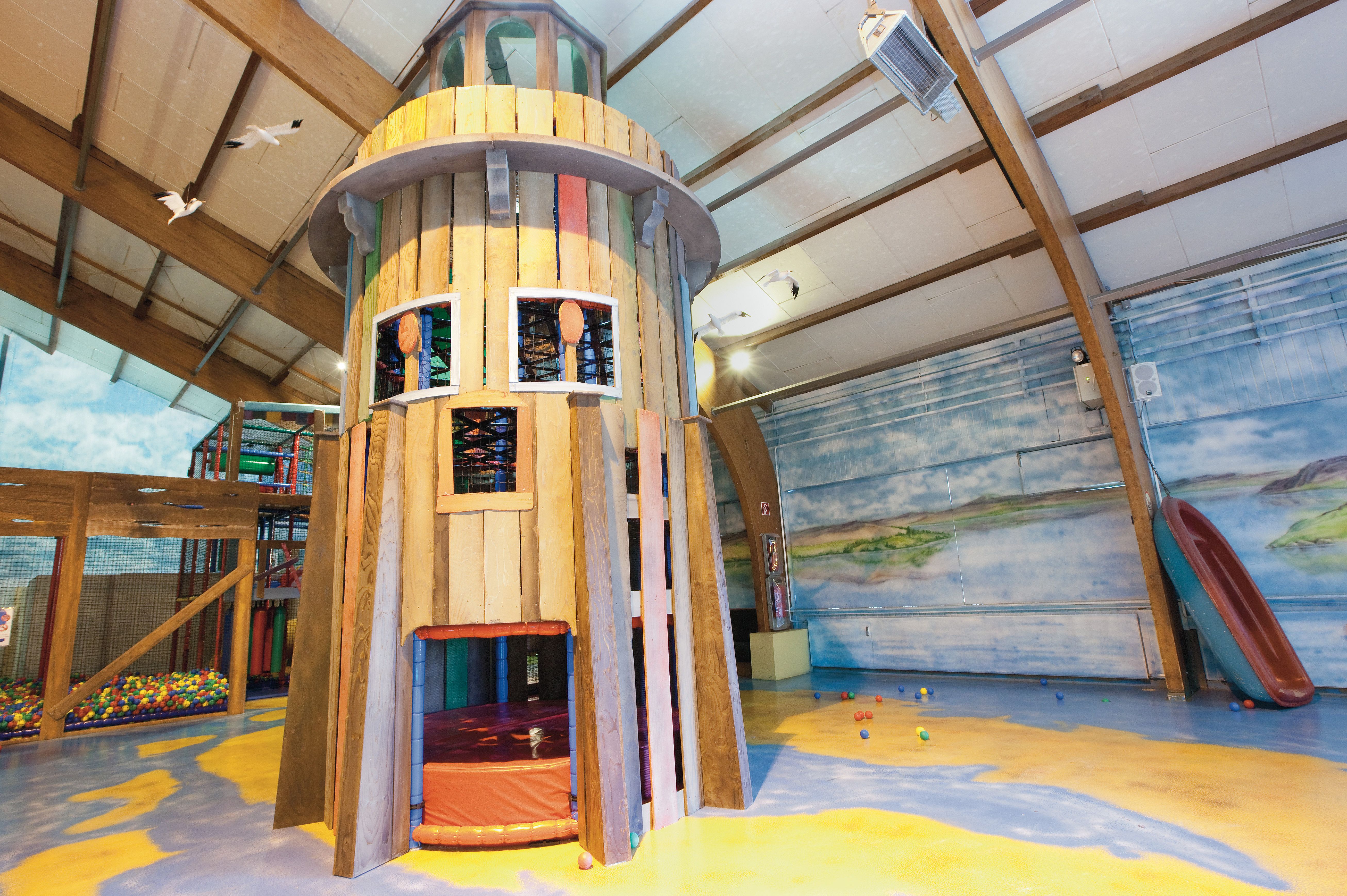 De hoge houten klimtoren in het indoorspeelparadijs van Landal Hochwald, met meerdere verdiepingen om te ontdekken.