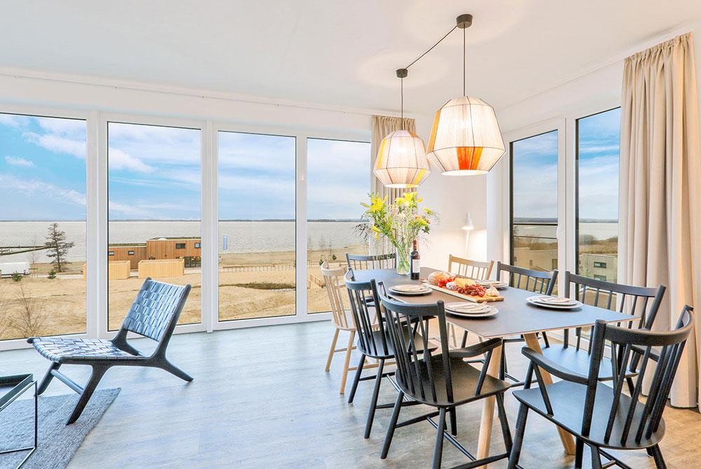 Ruime eetkamer met grote ramen en panoramisch uitzicht over het water en de omgeving bij Landal Marissa.