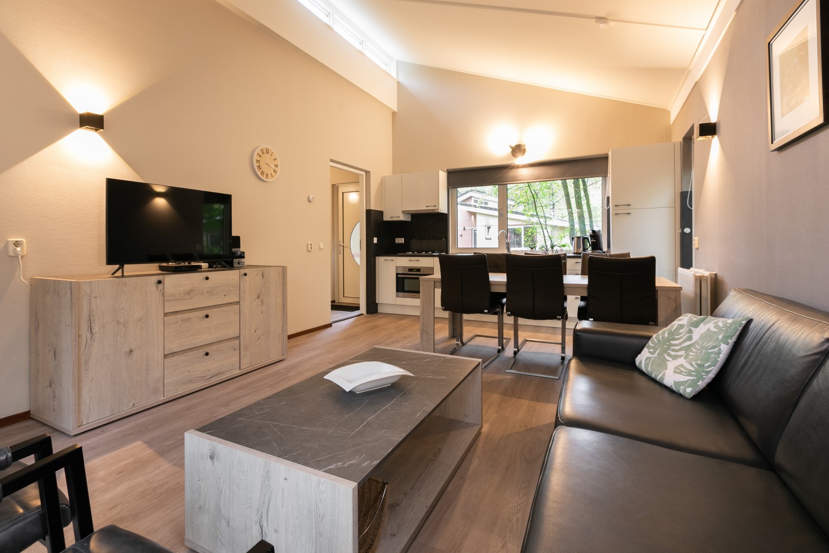 Overzicht van de moderne woonkamer met open keuken in een vakantiehuisje op Parc de Berkenhorst.