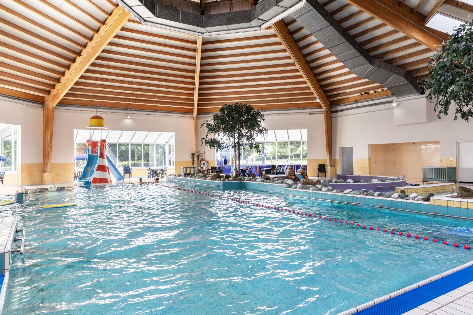 Het overdekte zwembad van Vakantiepark Port Greve in Zeeland, met een grote waterglijbaan en een apart peuterbad.