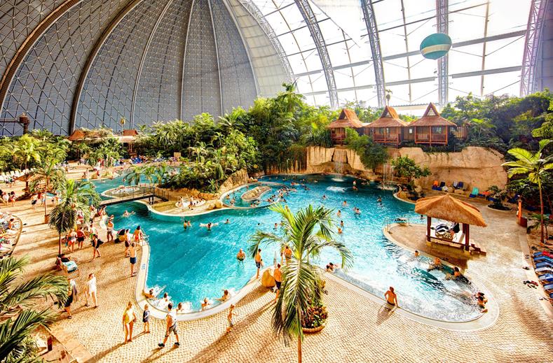 Overzicht van de 'Tropical Sea', het enorme zwembad met een 200 meter lang zandstrand, palmbomen en badgasten in het hart van Tropical Islands.