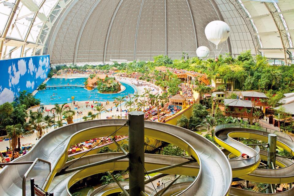 Overzicht van de 27 meter hoge glijbaantoren in het subtropische zwemparadijs van Tropical Islands, met uitzicht op de Tropical Sea en de enorme koepel.