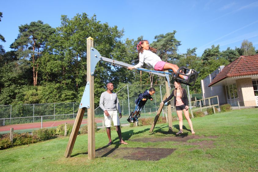Kinderen op schommels speeltuin Vakantiepark Hellendoorn buitenactiviteiten Overijssel