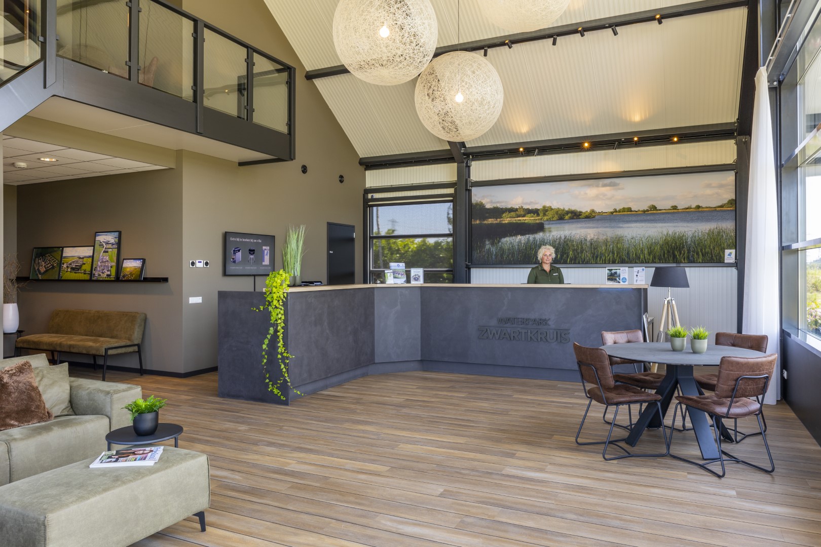 De ruime en lichte receptie en lounge van Waterpark Zwartkruis met een hoog plafond en modern interieur.