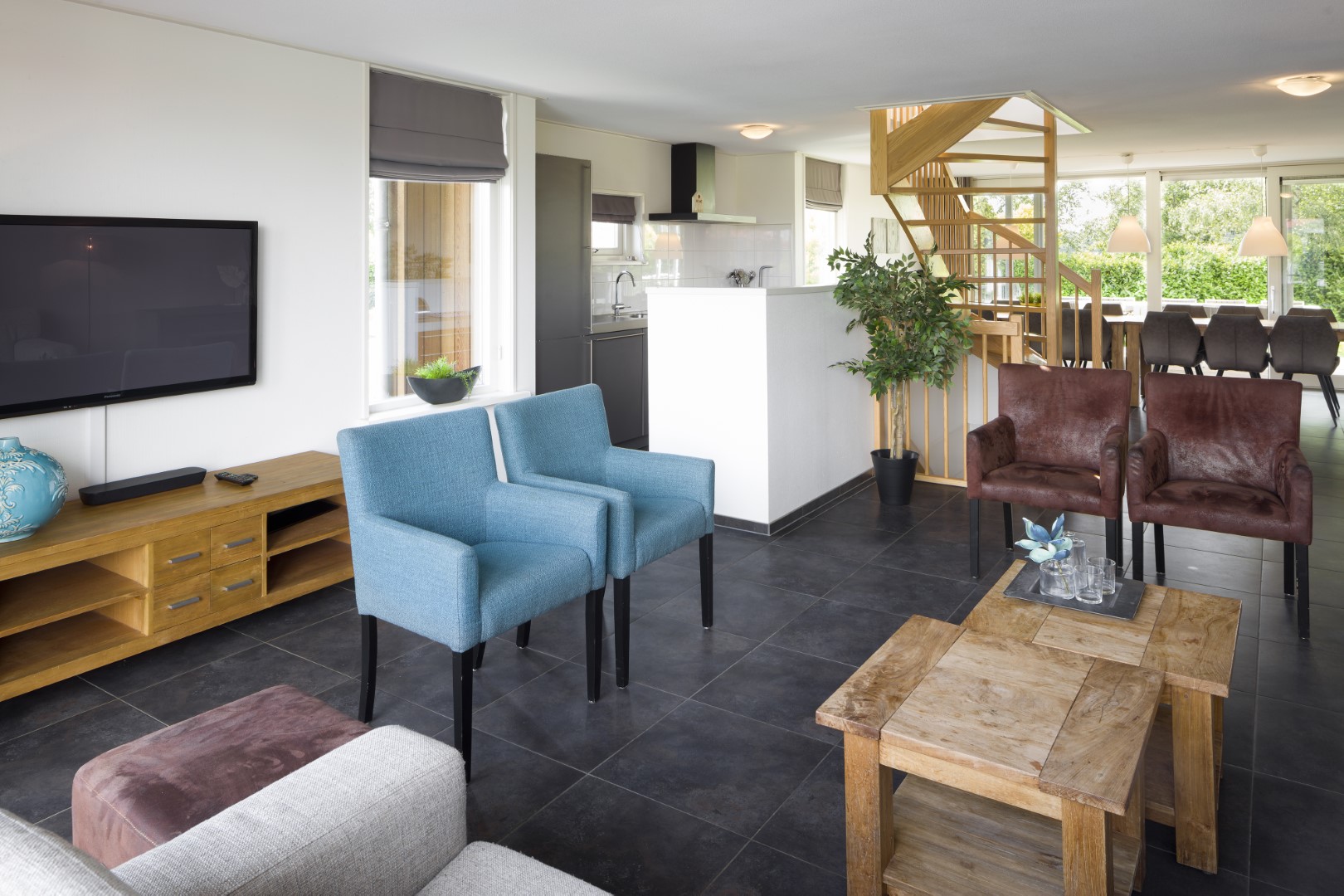 Het interieur van een waterwoning op Waterpark Zwartkruis, met een doorkijkje naar de woonkamer, open keuken en trap naar boven.